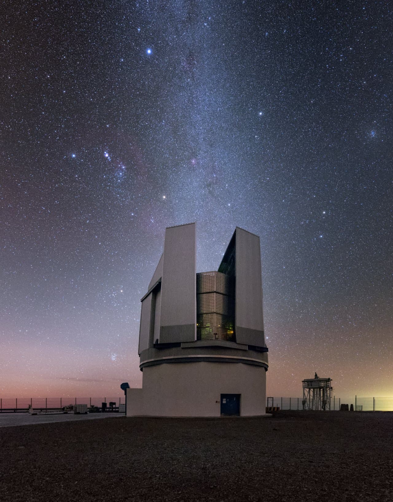 The soft glow of the Milky Way pours down like a waterfall over the VLT Survey Telescope (VST) at ESO’s Paranal Observatory. 2635 metres above sea level, the VST has an unparallelled view of the magnificently clear skies above Chile’s Atacama Desert. It is the largest telescope in the world dedicated to observational surveys in visible light, and it contributes to a vast range of studies, from discovering remote Solar System bodies to searching for exoplanet transits, to studying the structure and evolution of our galax.